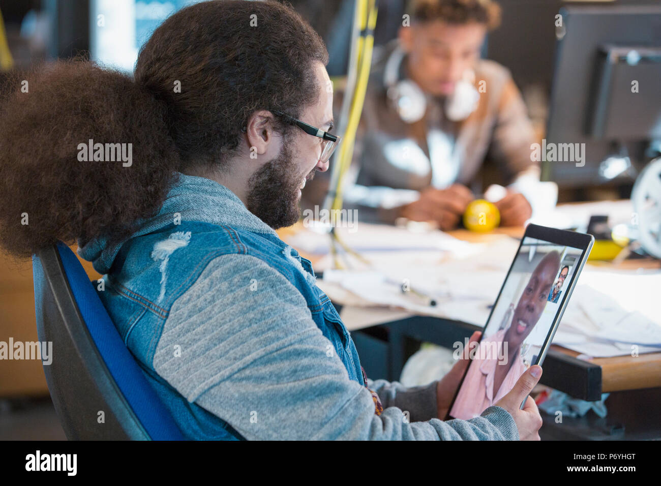 Creative businessman video chatting with colleague in office Stock Photo