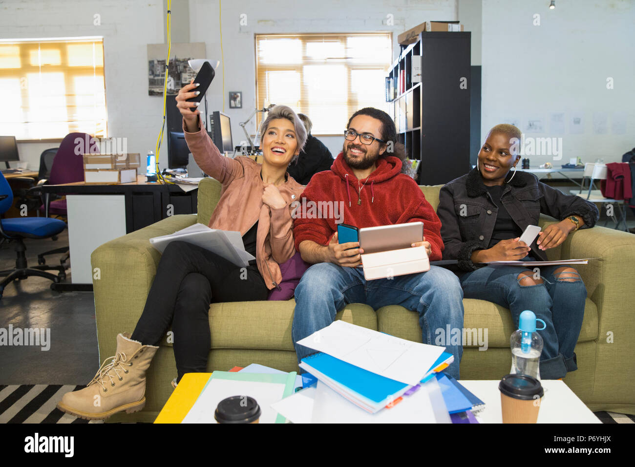 Happy creative business people taking selfie in casual open plan office Stock Photo
