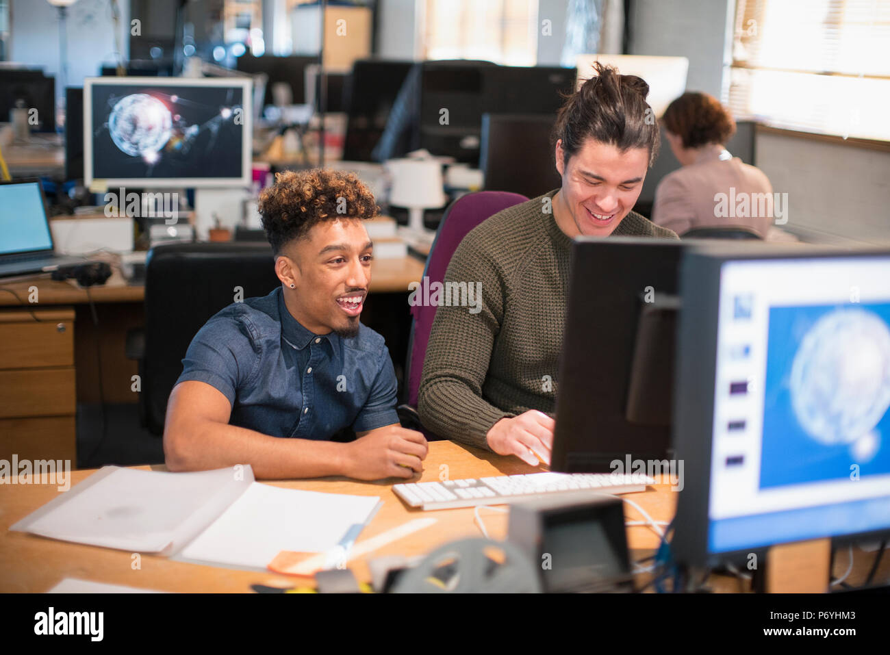 Creative businessmen working at computer in open plan office Stock Photo