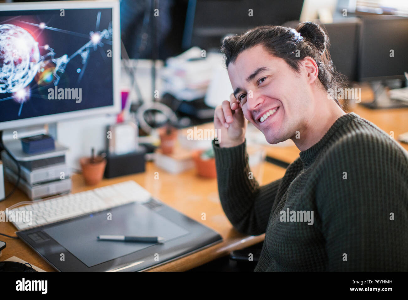 Portrait smiling, confident male graphic designer working at desk Stock Photo