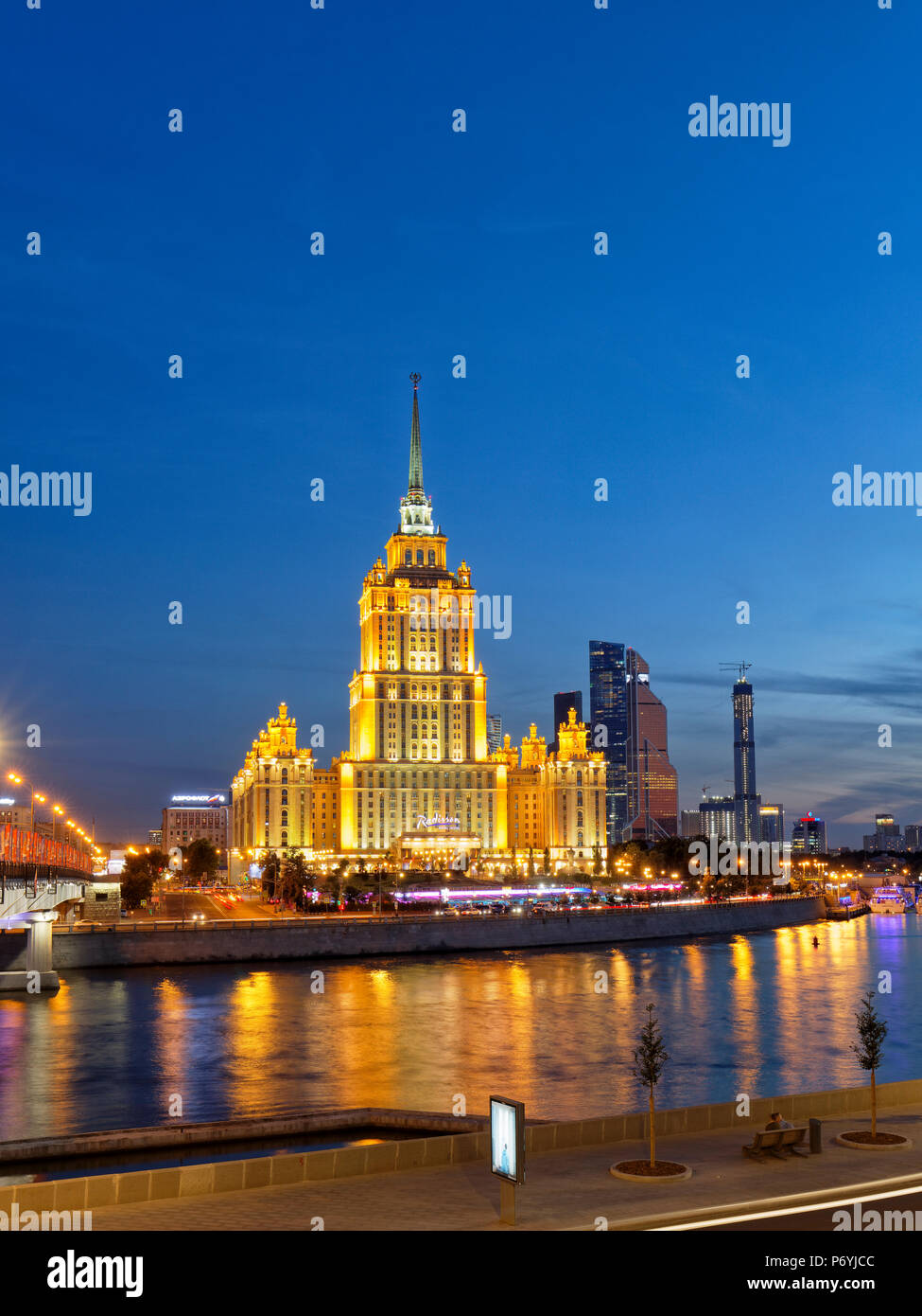 Radisson Royal Hotel Stalinist style high-rise building on Moskva River illuminated at dusk. Moscow, Russia. Stock Photo