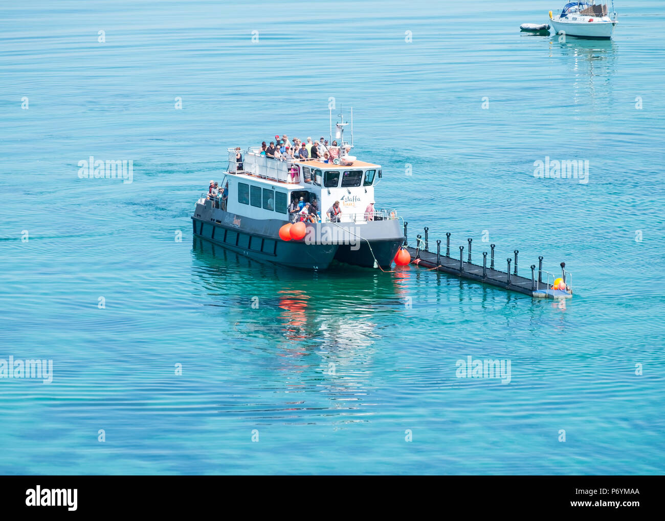 Tour boat using a floating pontoon to access Lunga, Treshnish Isles, Scotland. There is no permanent dock or slipway on the island. Stock Photo