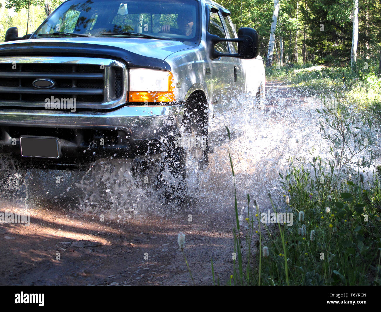 Silver Four Wheel Drive Pick Up Truck Splashing Through Mountain Stream