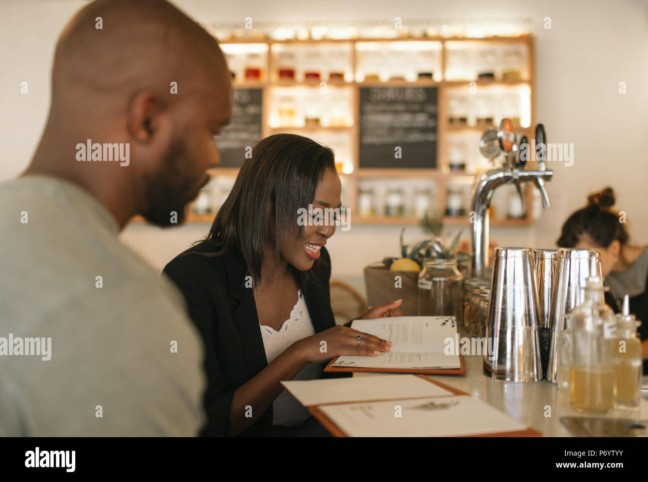 Smiling young African American couple reading menus in a bar Stock Photo