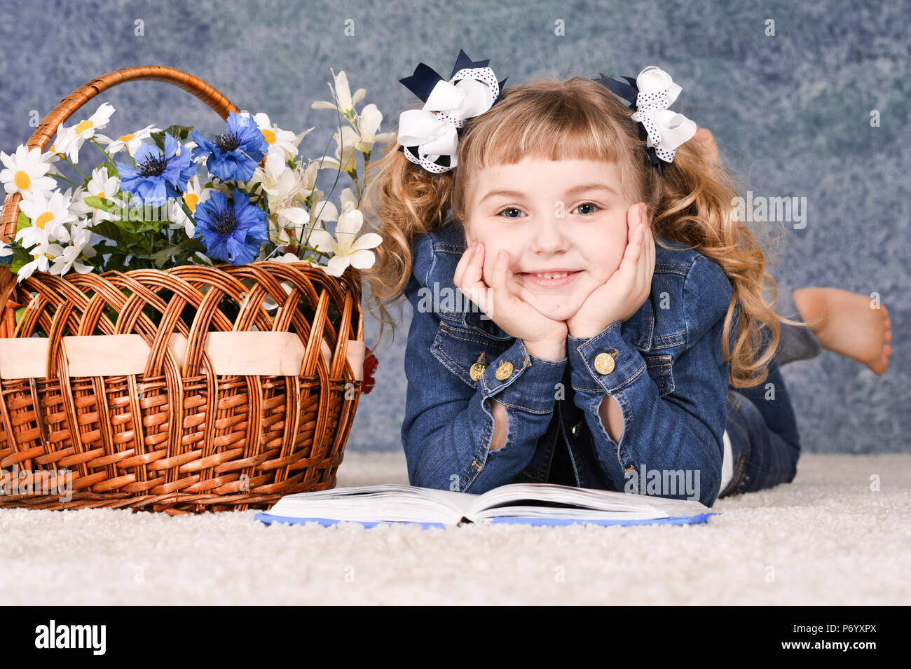 little girl reading book while lying on floor Stock Photo - Alamy
