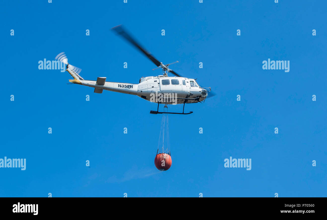 A helicopter carrying water, as firefighters continue to work on Winter Hill near Bolton Stock