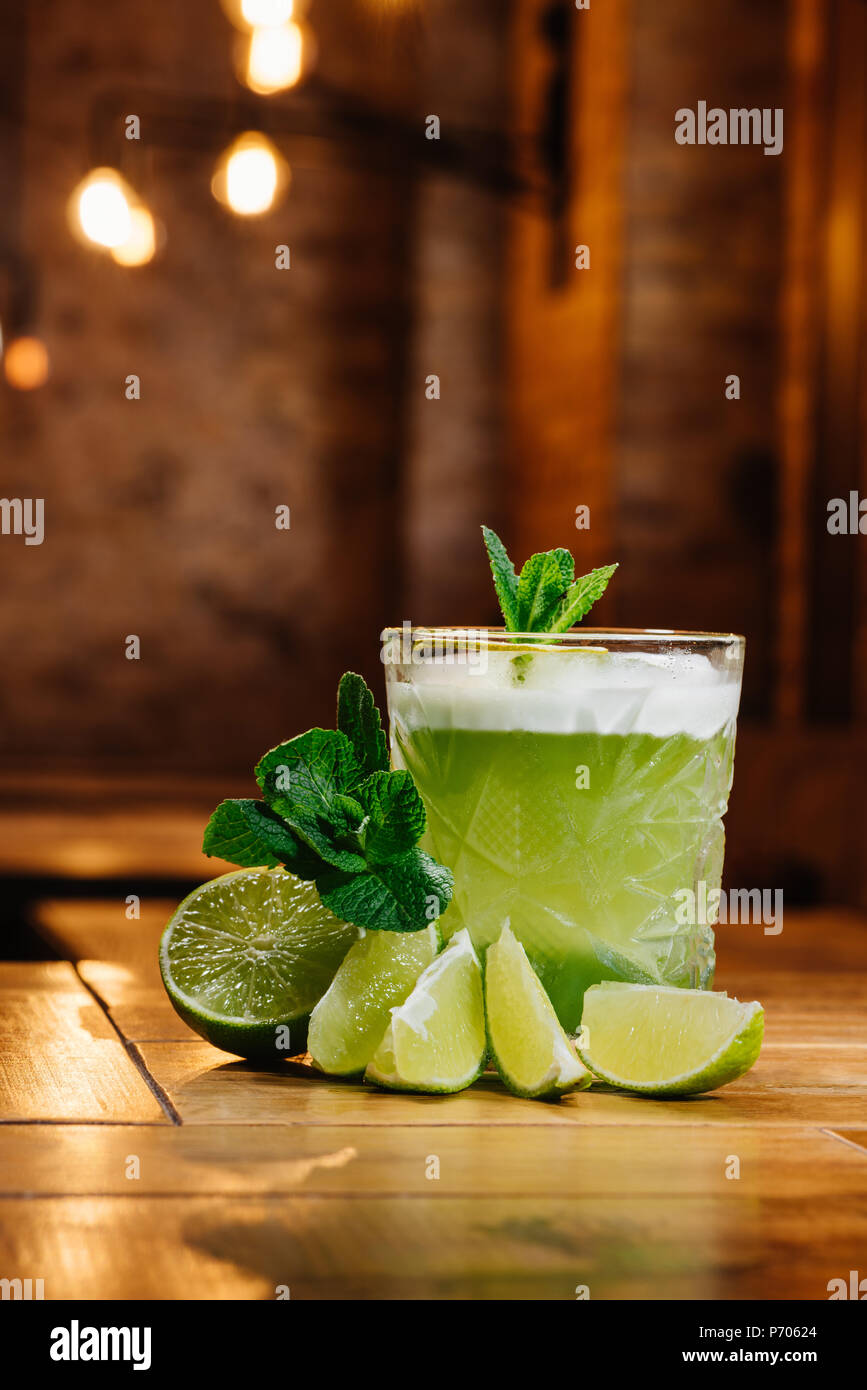 close-up view of green van gogh cocktail in glass with mint and lime on wooden table Stock Photo