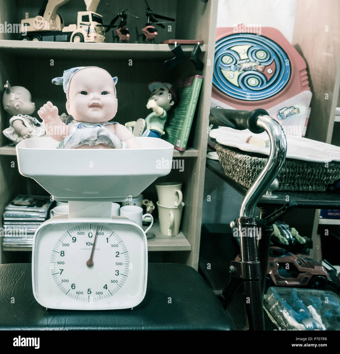 Baby doll on scales in charity shop. Stock Photo