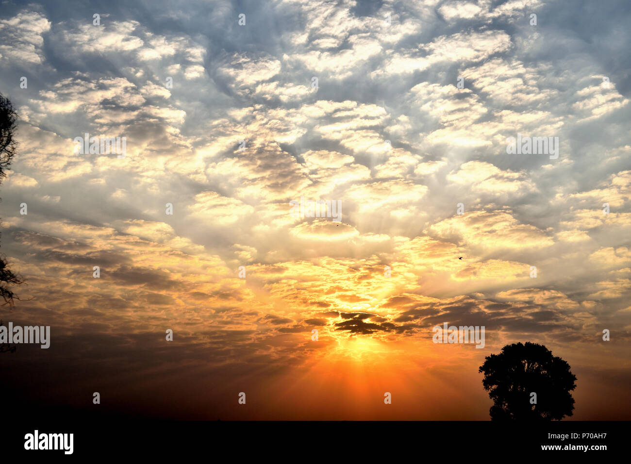 Dispersion of light wavelengths during sunset in cloudy sky Stock Photo