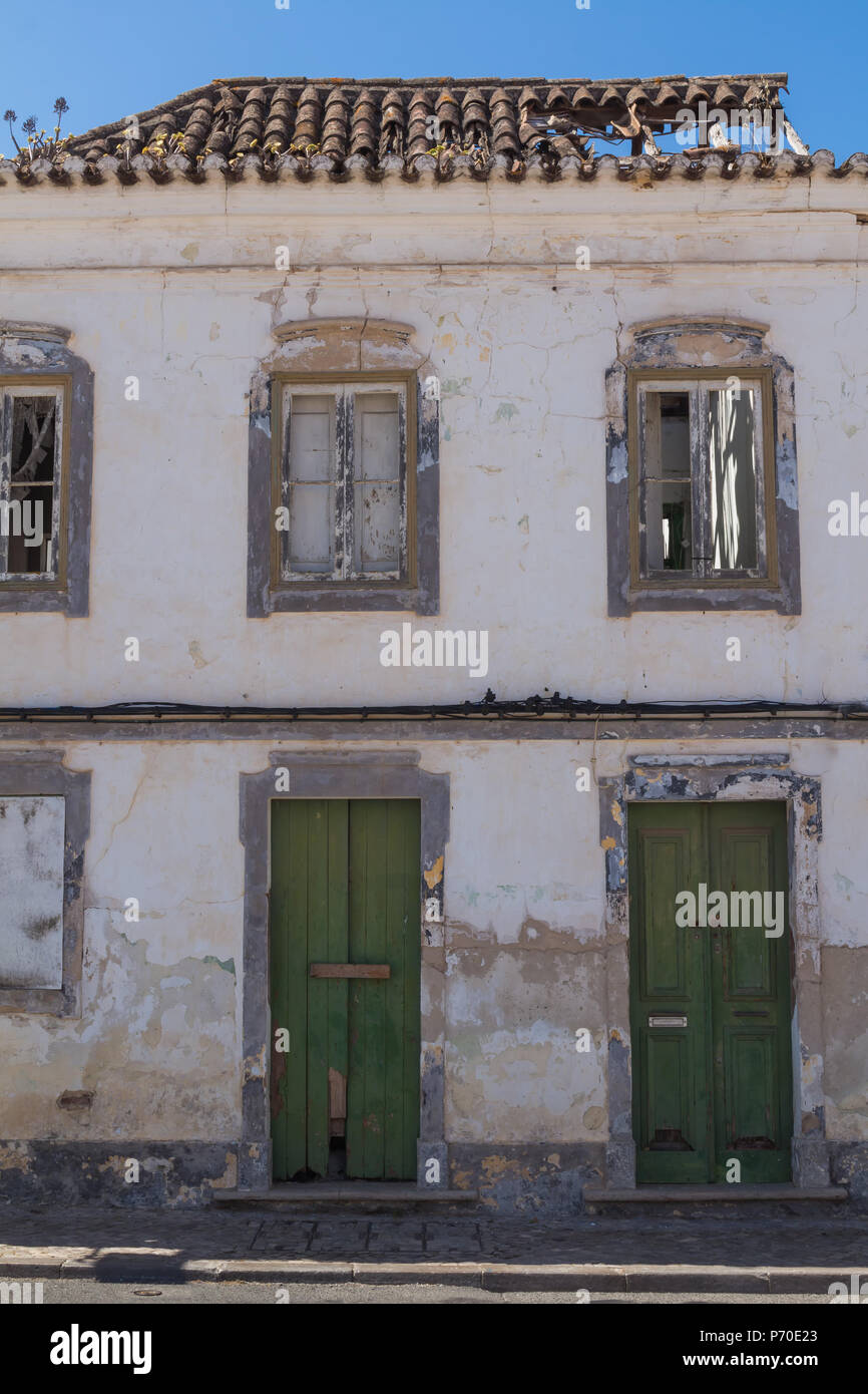 Front Part Of An Abandoned House With Green Door Broken Windows
