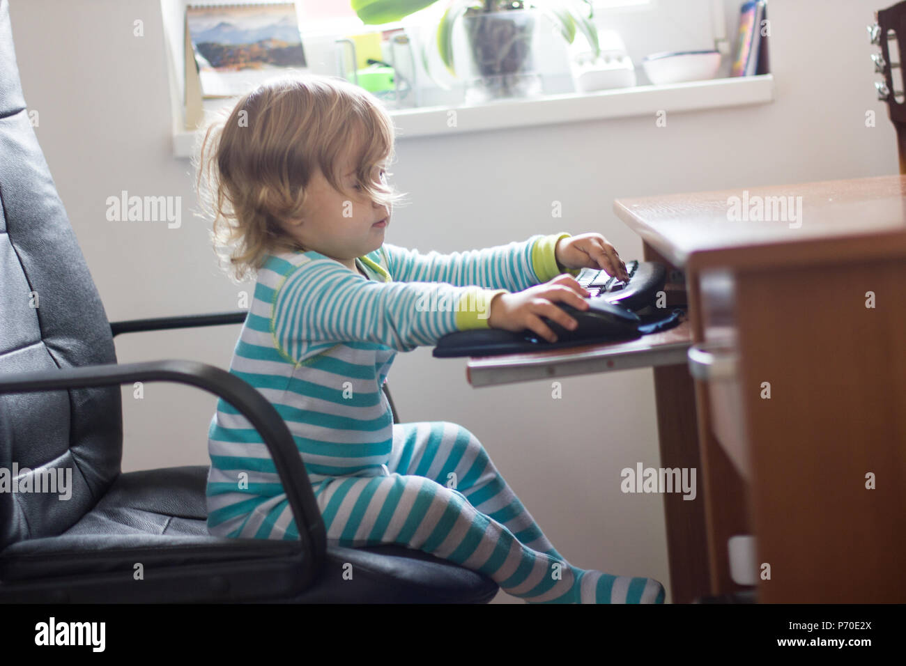 Childhood and technology ,Two years child using computer at home Stock ...