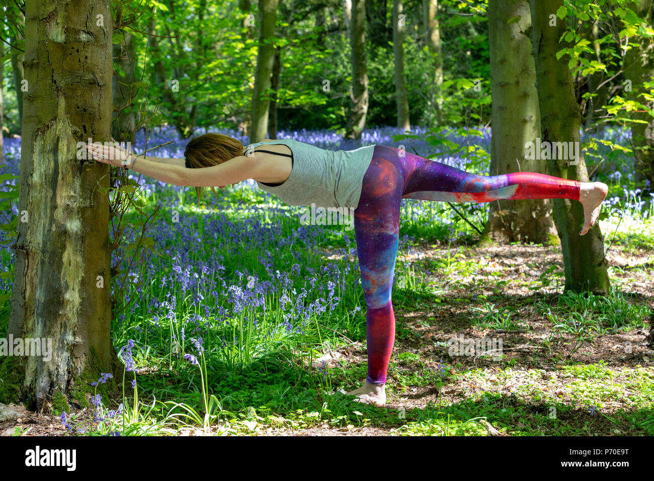 A yoga instructor demonstrates yoga poses during an outdoor yoga A yoga instructor demonstrates yoga poses during an outdoor yoga