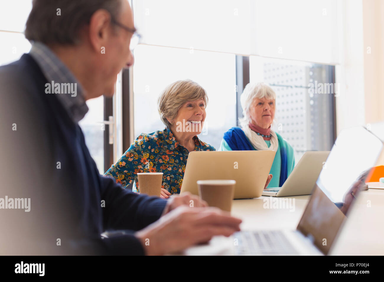 Senior businesswomen using laptops in conference room meeting Stock Photo