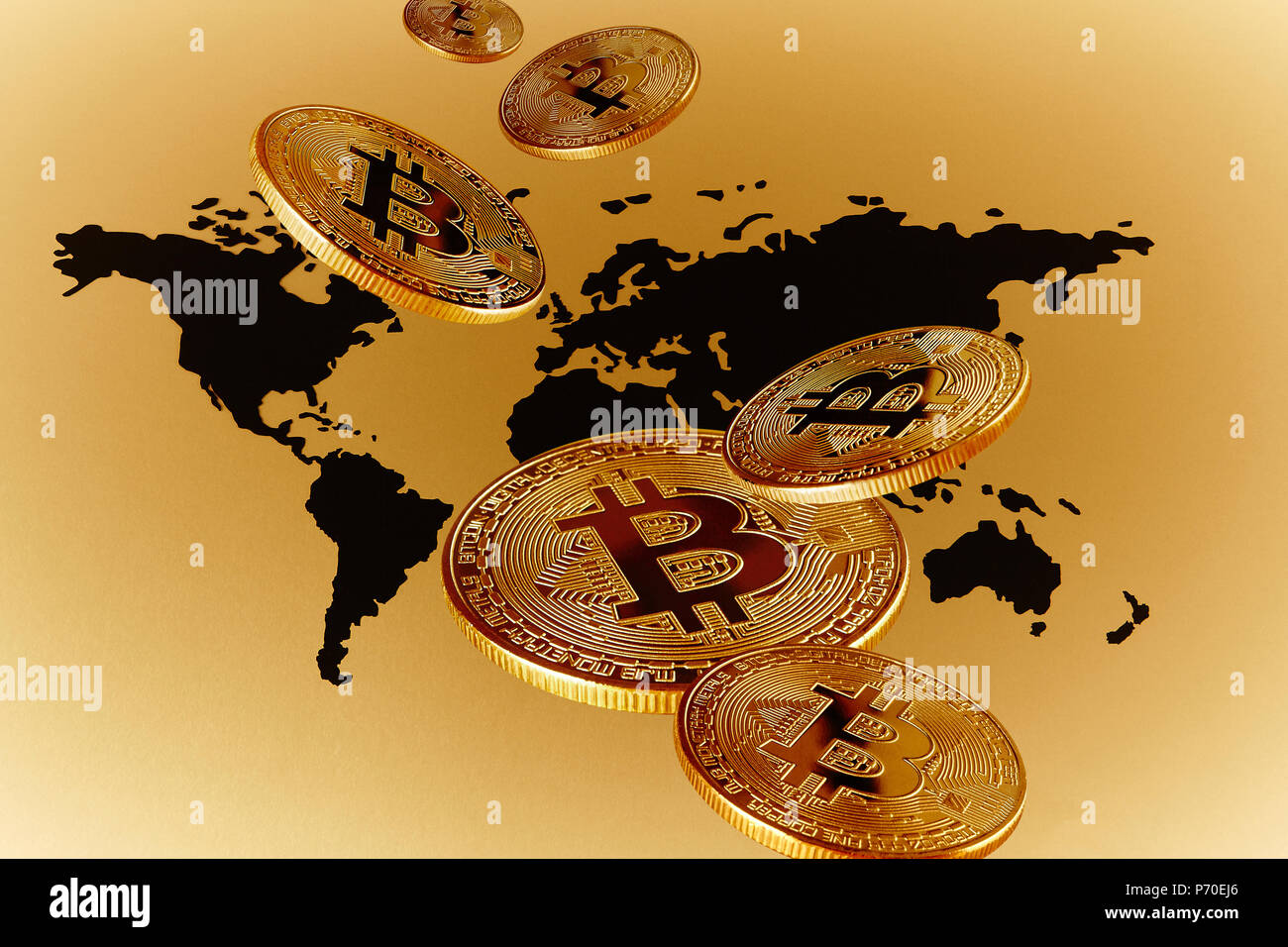 Golden Bitcoins over global map Stock Photo