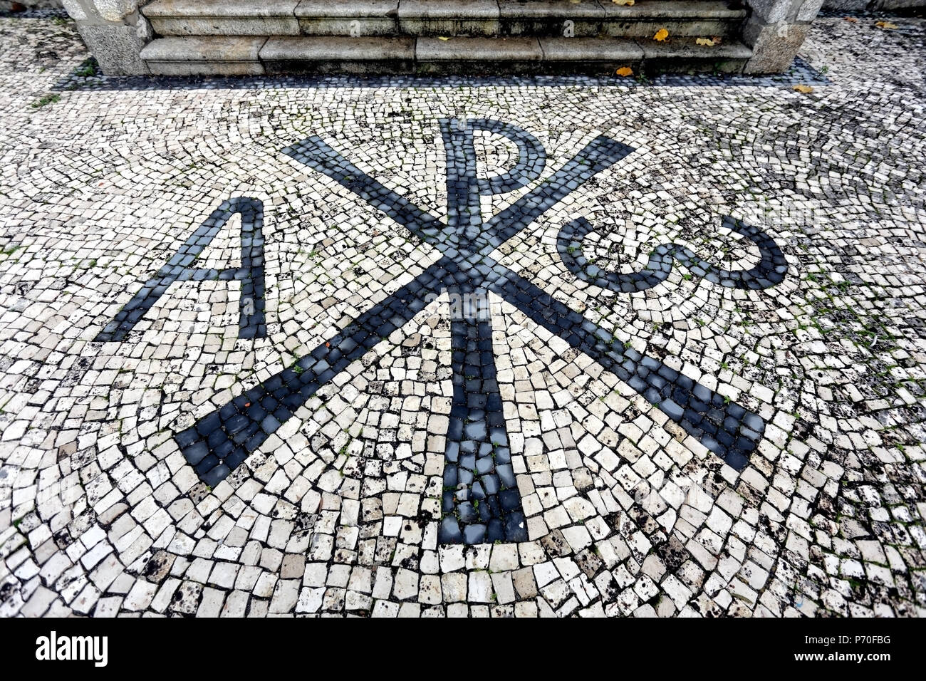 Part of the backyard of a northern church in Portugal with christian symbols. Portuguese pavement style, a traditional-style pavement used in pedestri Stock Photo