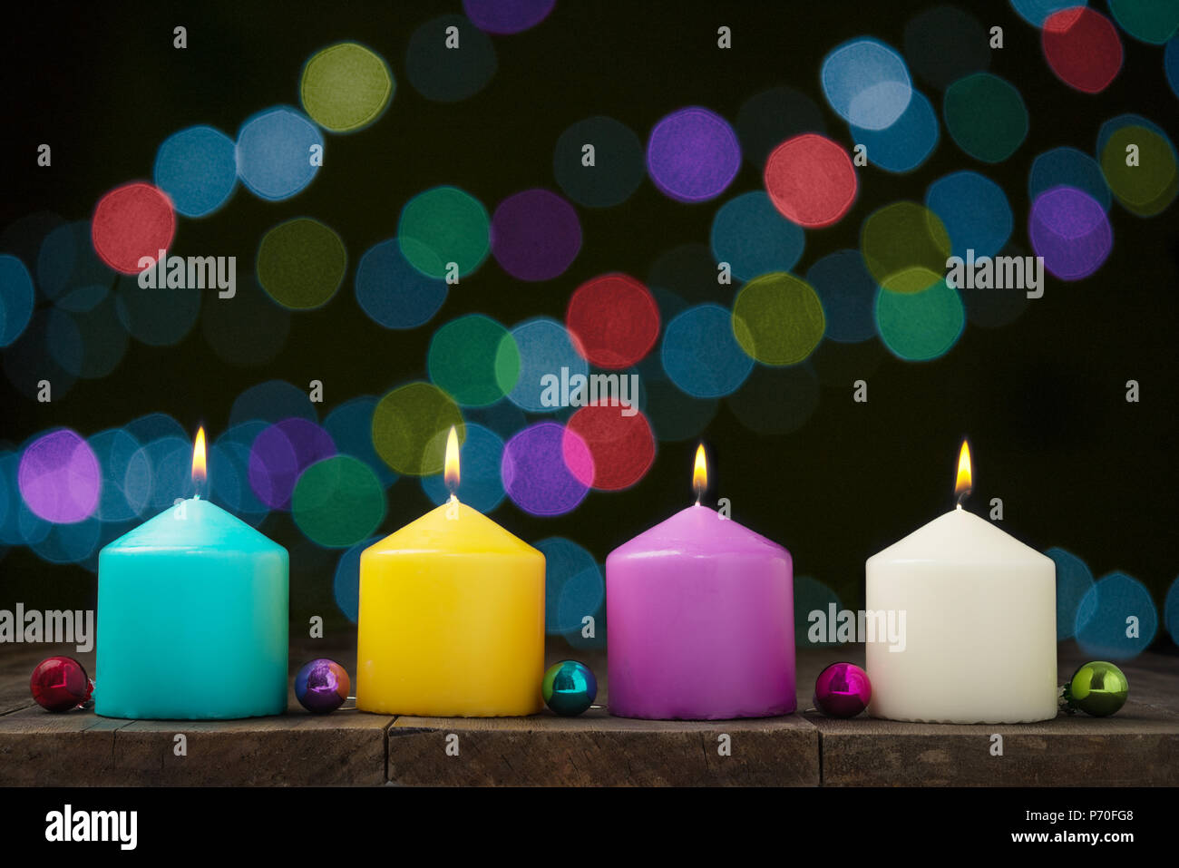 Multicolored burning candles with bokeh on black background.Concept of New Year and Xmas Stock Photo