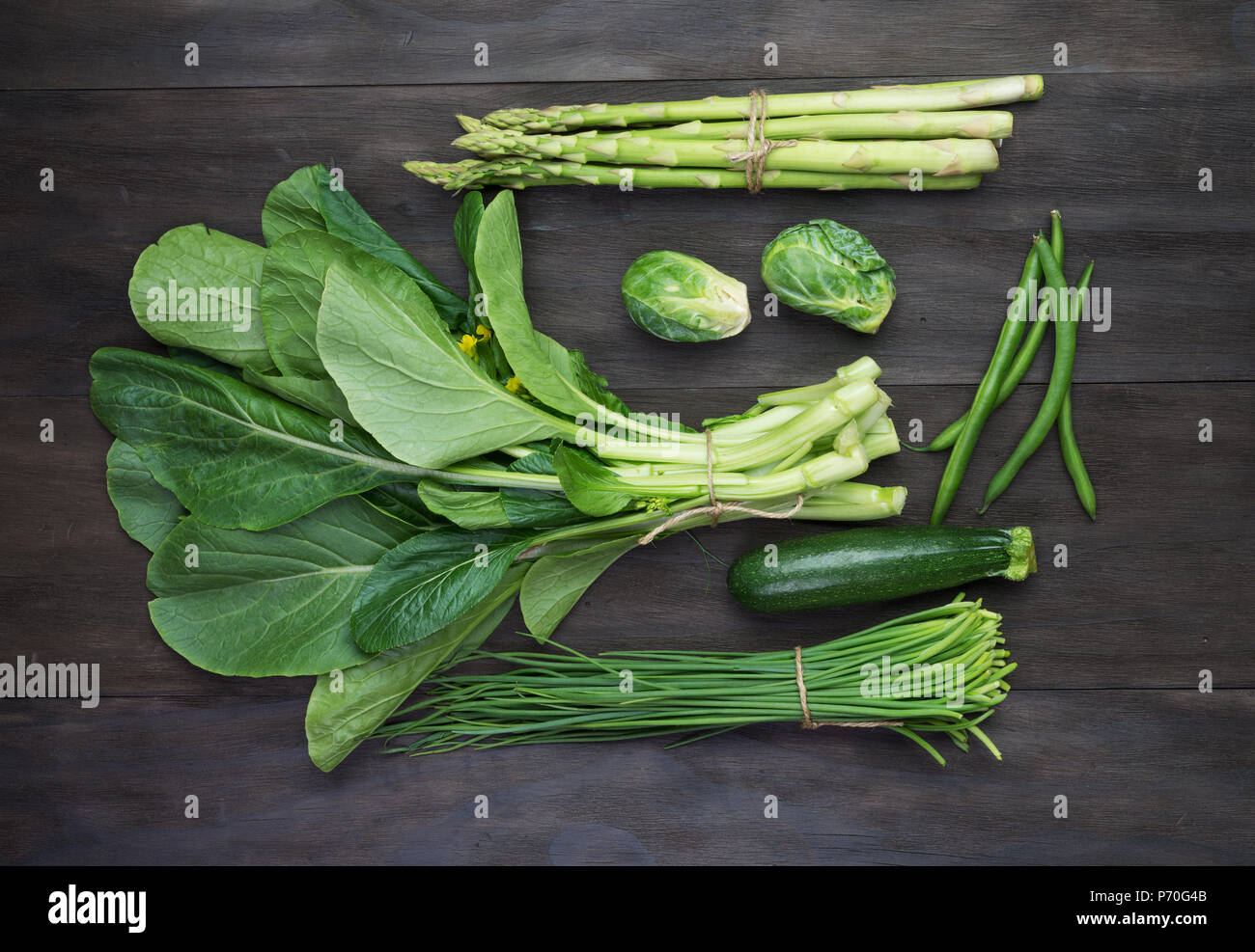 Fresh green organic vegetables on black wooden vintage table.Top view Stock Photo