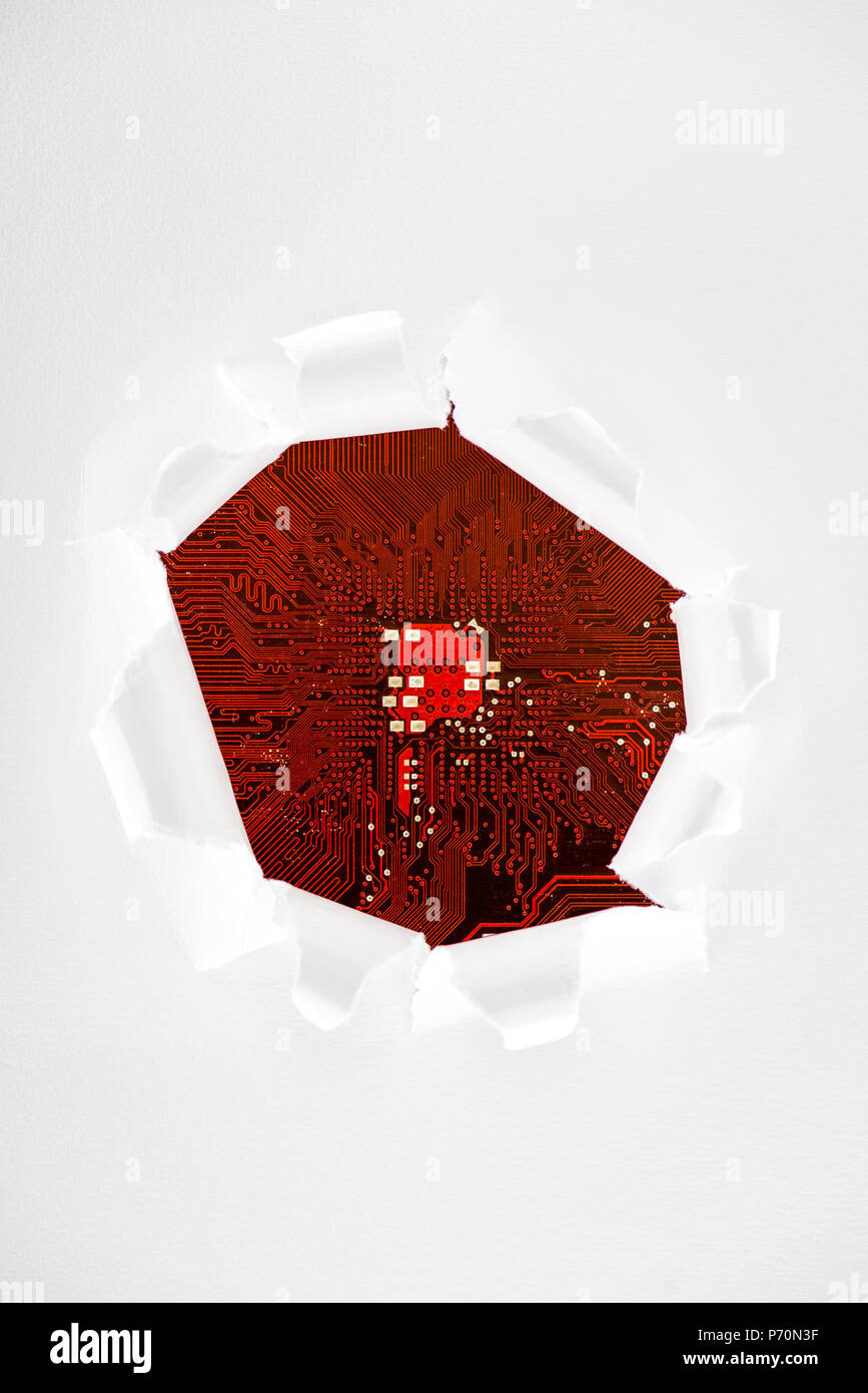 Typical desktop computer logic board closeup view through ripped paper