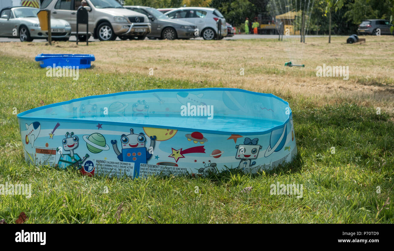 A paddling pool filled with cool water on a hot sunny heatwave day Stock Photo