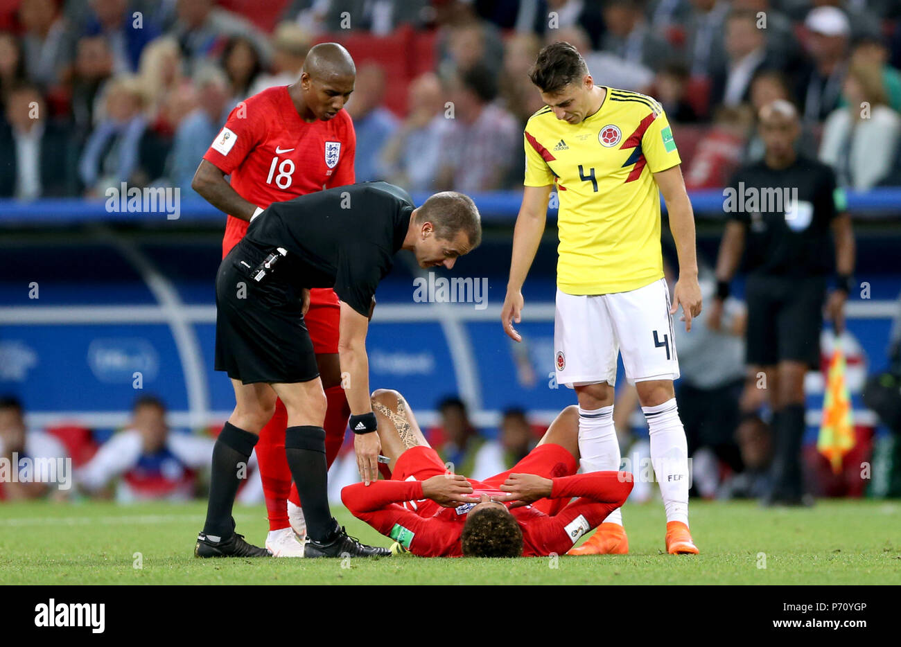 Referee Mark Geiger looks over England's Dele Alli as he lies on the ground after being tackled by Colombia's Santiago Arias during the FIFA World Cup 2018, round of 16 match at the Spartak Stadium, Moscow. Stock Photo
