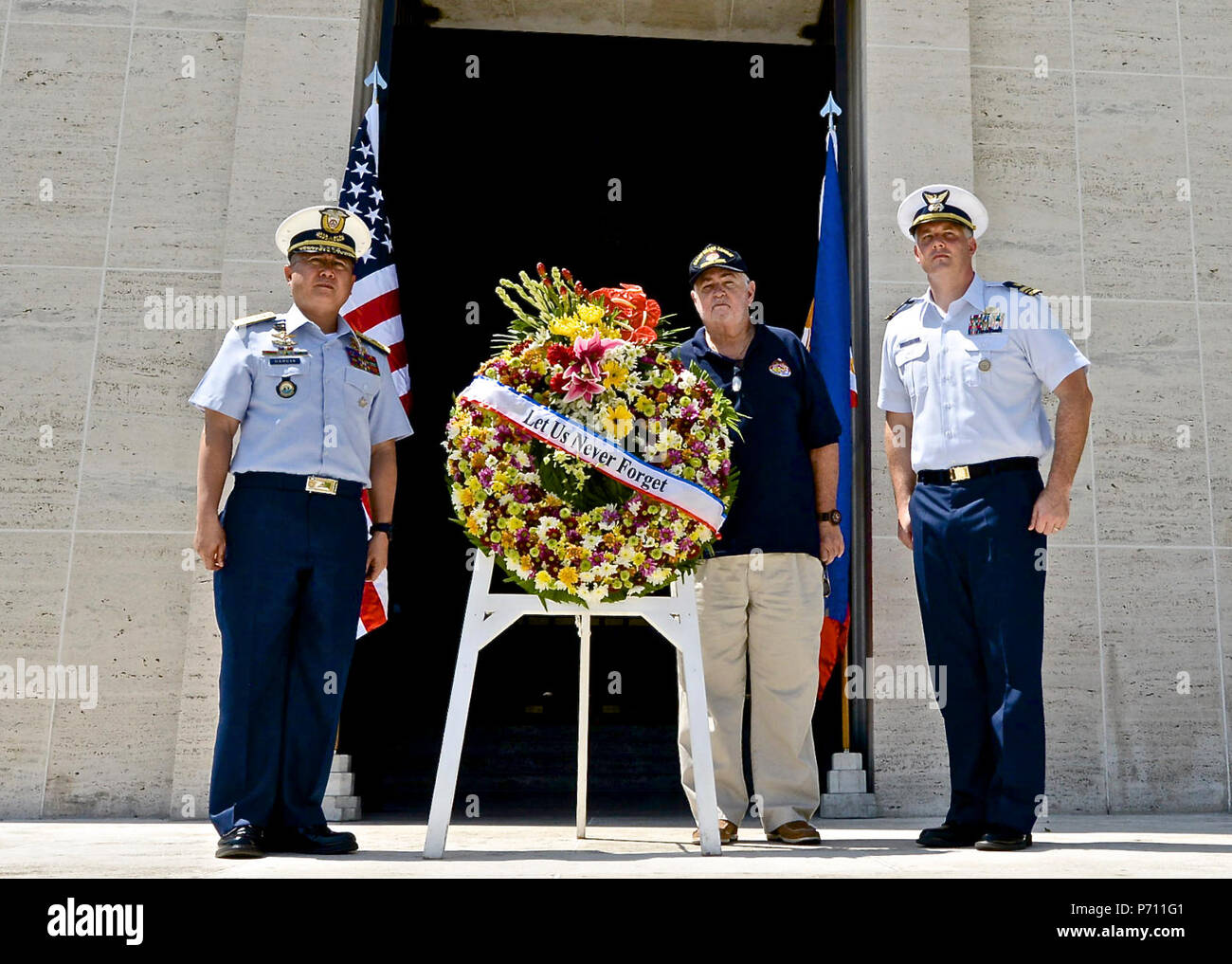 Officer-in-Charge Commodore Joel Garcia, Philippine coast guard, Lt. Cmdr, Jeremy Obenchain ,U.S. Coast Guard, maritime advisor Defense Threat Reduction Agency and U.S. Embassy, and Chief Petty Officer John O’Neil, U.S. Coast Guard Combat Veterans Association,  lay a wreath at the Military American Cemetery chapel, May 9, 2017. The ceremony was culminated with the reveal of  Lt. Crotty’s name now etched on the U.S. Coast Guard wall in the cemetery. Stock Photo