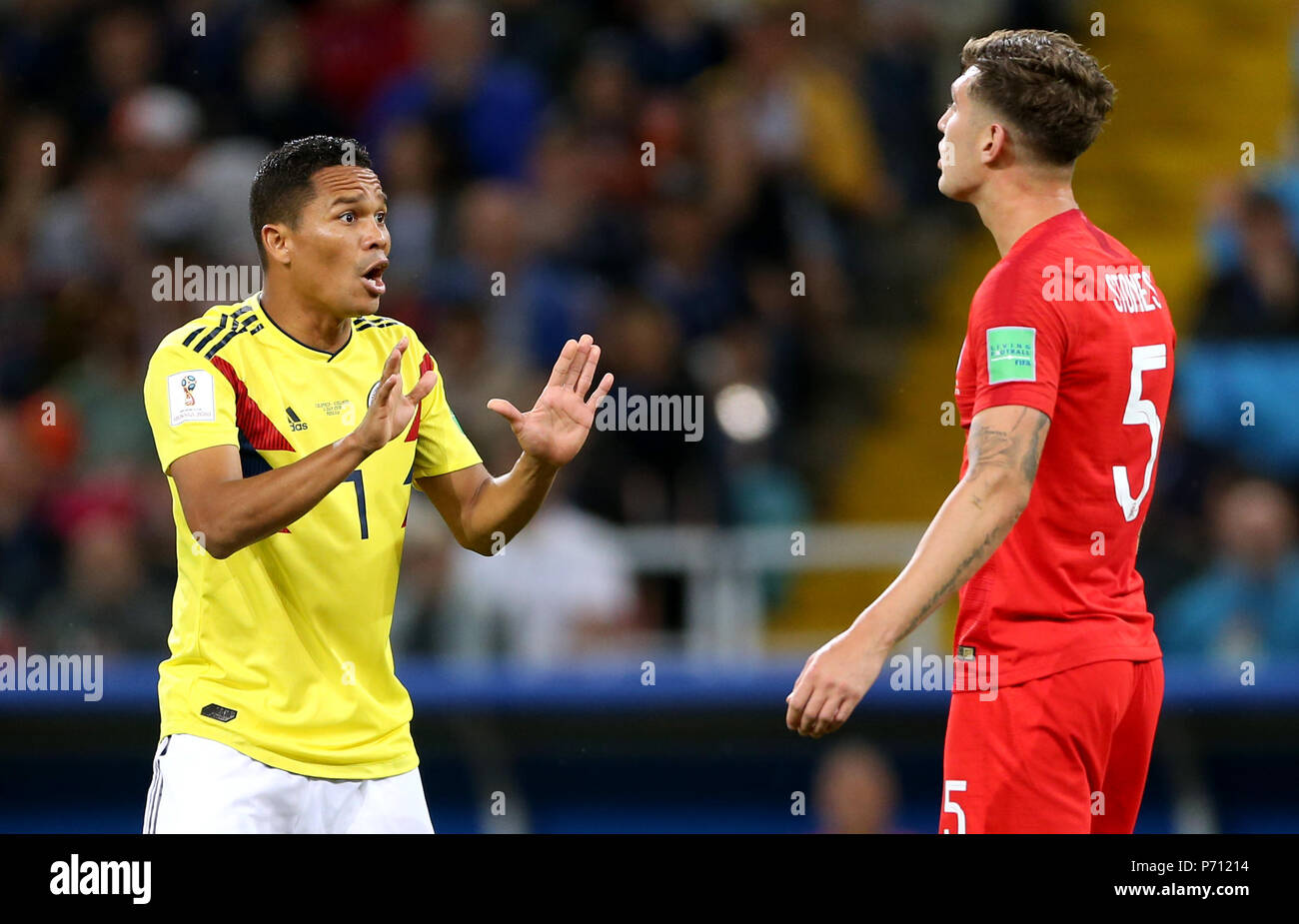 Colombia's Carlos Bacca (left) talks to England's John Stones after receiving a yellow card during the FIFA World Cup 2018, round of 16 match at the Spartak Stadium, Moscow. Stock Photo