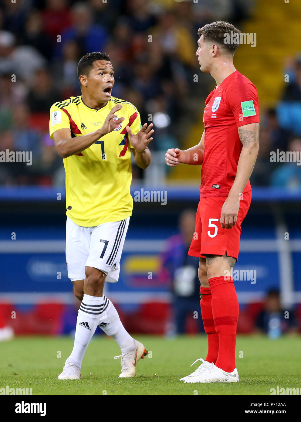 Colombia's Carlos Bacca (left) talks to England's John Stones after receiving a yellow card during the FIFA World Cup 2018, round of 16 match at the Spartak Stadium, Moscow. Stock Photo