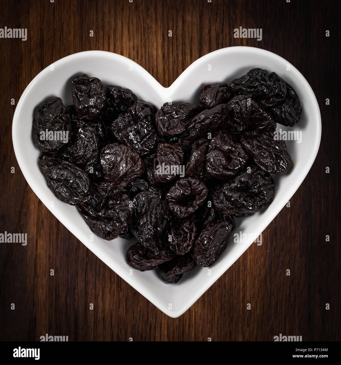 Dried Plums Pitted Prunes in Heart Shaped Bowl Background Stock Photo