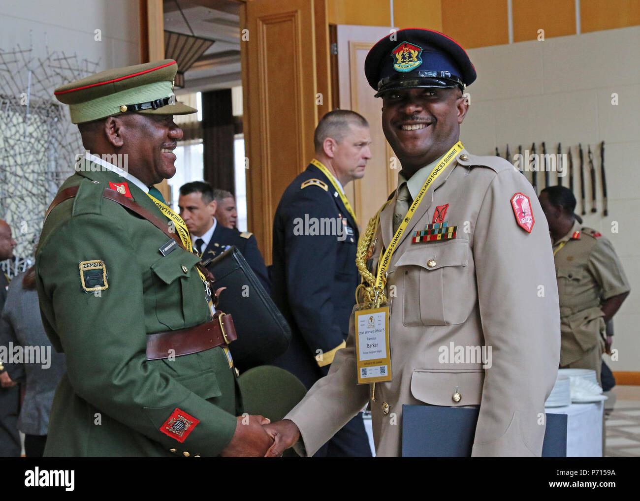 Warrant Officer 1 Patson Mwanakanje (left), a member of the Zambian Army headquarters, and Chief Warrant Officer 5 Ramous Barker, Republic of Ghana Forces Sergeant Major, socialize during the African Land Forces Summit, in Lilongwe, Malawi, May 11, 2017. ALFS is an annual, weeklong seminar bringing together land force chiefs from across Africa for candid dialog to discuss and develop cooperative solutions to regional and transregional challenges and threats. Stock Photo