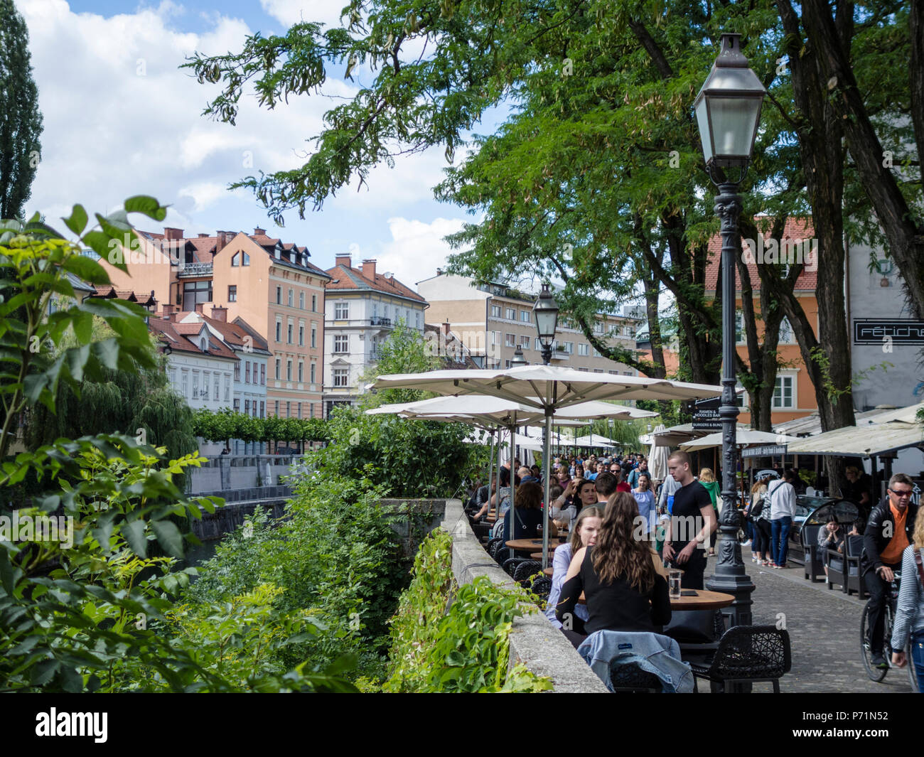 people-sitting-in-caf-s-along-the-river-ljubljana-downtown-stock-photo