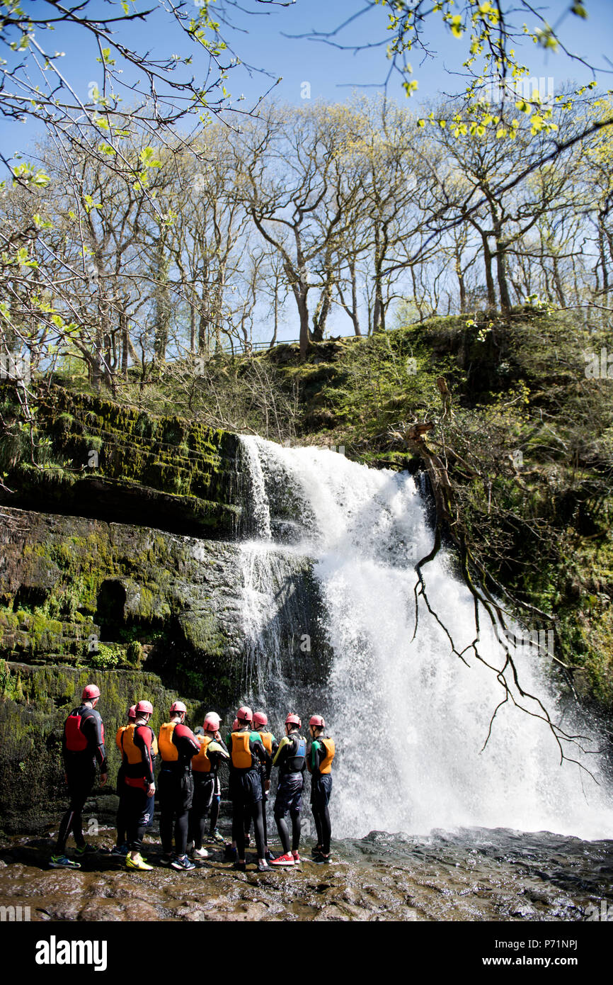 An instructor supervises a group walking with Adventure Wales on