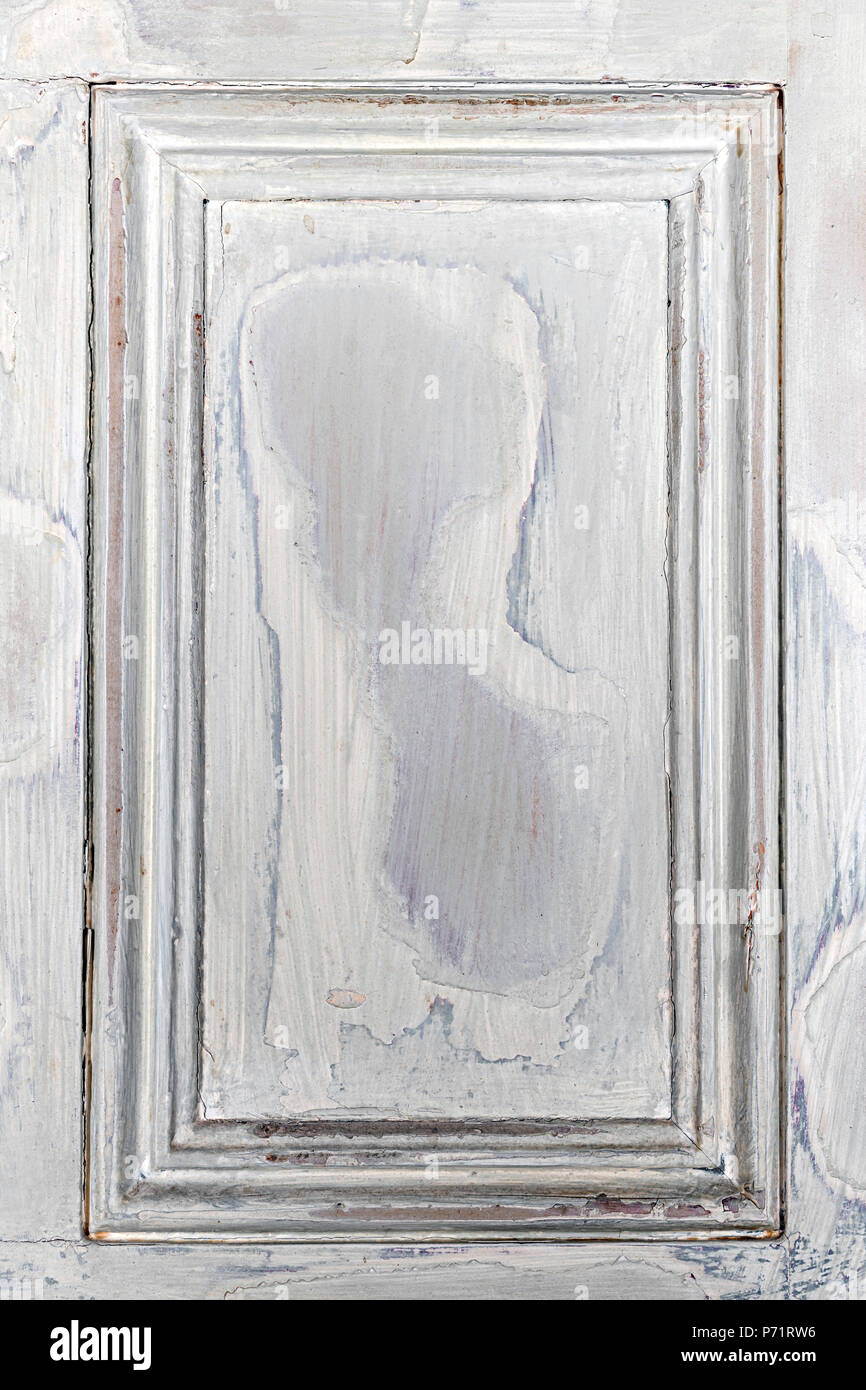 Old distressed wood door panel with peeling paint as framed background Stock Photo