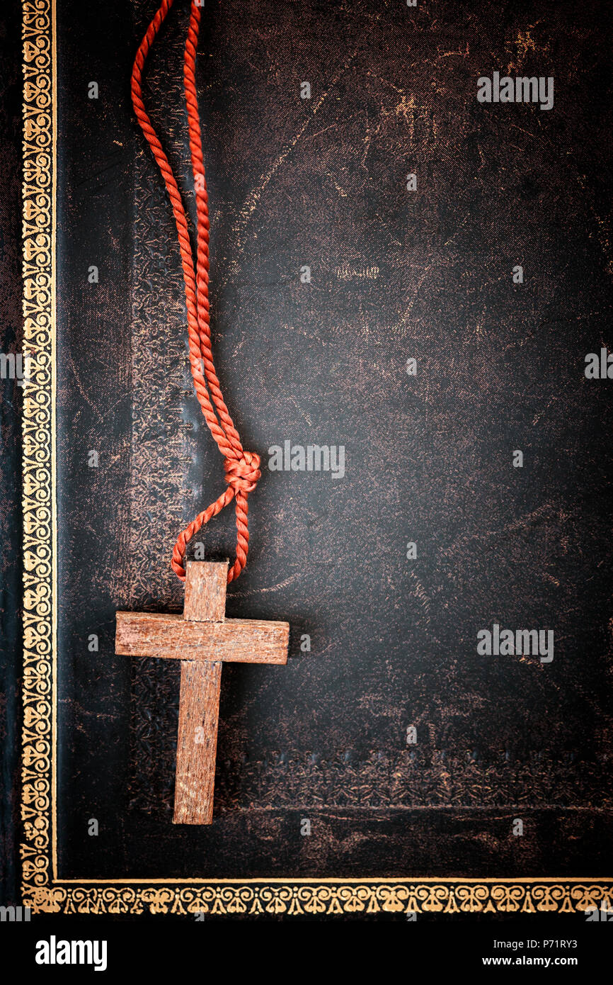 Closeup of simple wooden Christian cross necklace on holy Bible with copy space Stock Photo