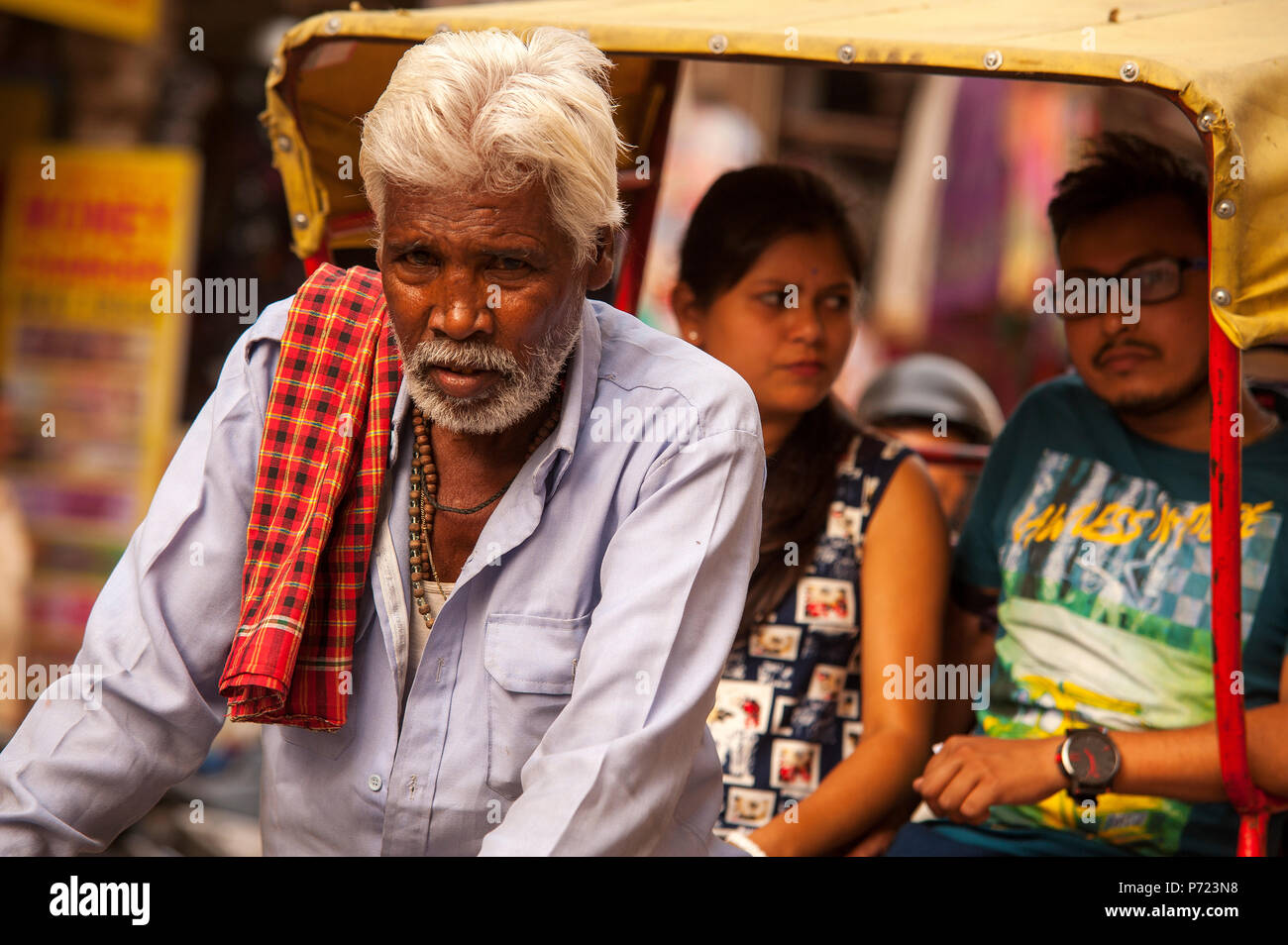 Old indian man taking passengers on his bicycle tuk tuk at Main Bazar Paharganj, New Delhi, India Stock Photo