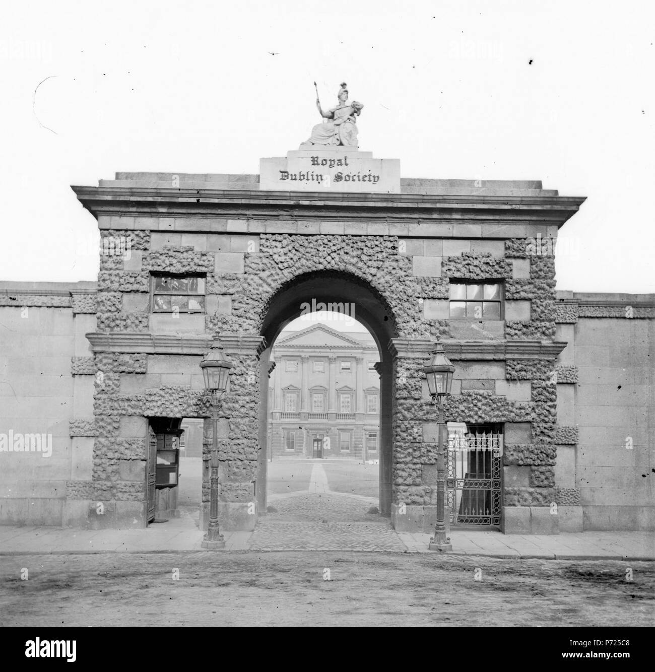 This was the entrance arch to Leinster House (next door to Library Towers) back in the days when it was home to the Royal Dublin Society, whose original collections formed the basis of ours here at the National Library of Ireland. It looks quite imposing, and it's lovely to see the notices for presumably forthcoming lectures, etc. - a bit blurry, but one definitely says BOTANY. I had assumed the figure of Minerva had been relocated to the 'new' RDS in Ballsbridge, but she's not on any of the buildings there that I could see. So, where is Minerva now Date: 1863-1880 NLI Ref.: <a href='http://ca Stock Photo