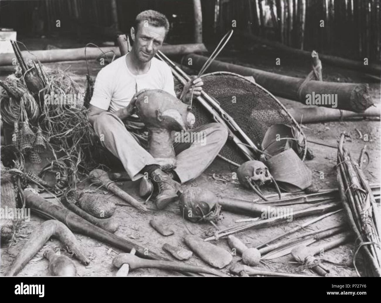 English Allan Riverstone McCulloch surrounded by souvenirs in Papua
