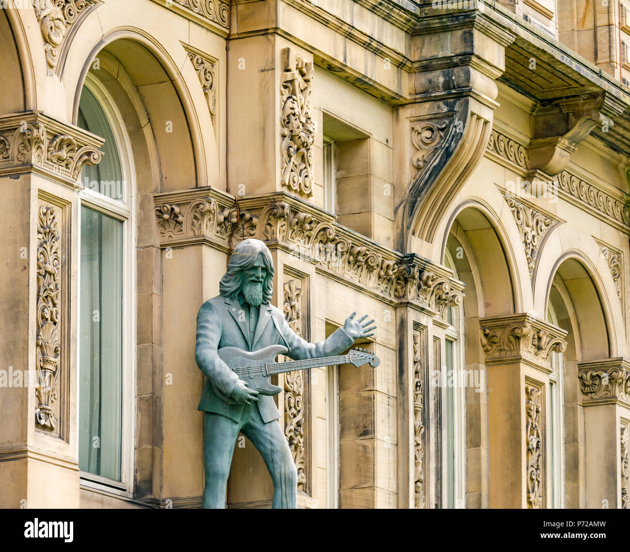 Statue of George Harrison playing a guitar outside Hard Day's Night Hotel, North John Street, Liverpool, England, UK Stock Photo