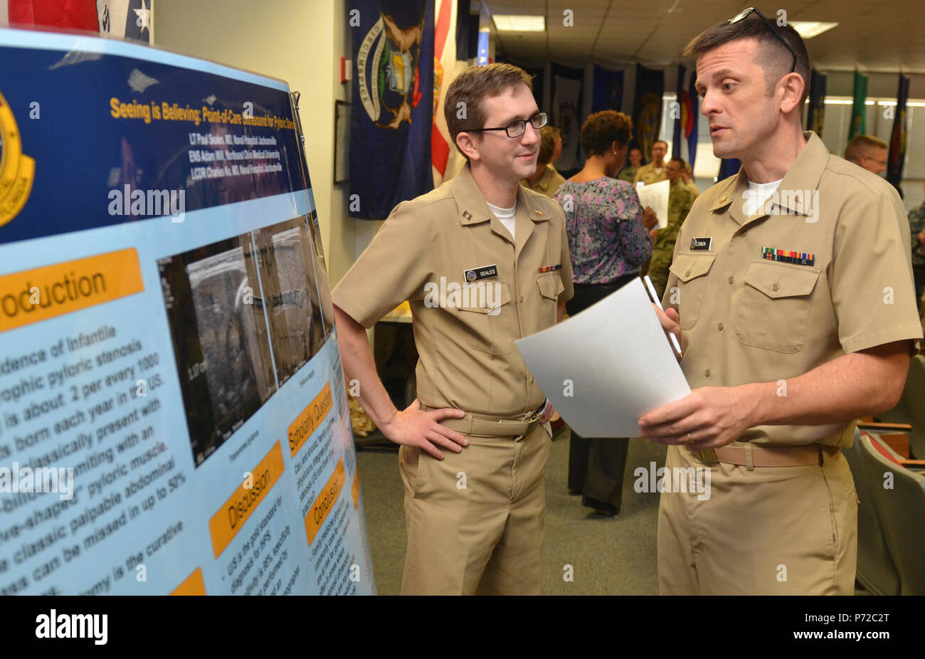 JACKSONVILLE, Fla. (May 11, 2017) – Lt. Paul Seales (left), a Naval Hospital (NH) Jacksonville family medicine resident physician, discusses his research project during the command’s Research Symposium. Event participants also included: St. Vincent’s HealthCare, Eisenhower Army Medical Center, and Womack Army Medical Center.  NH Jacksonville is home to the Navy’s largest and oldest family medicine residency program and has earned numerous awards for scholarly activity and teaching. Stock Photo