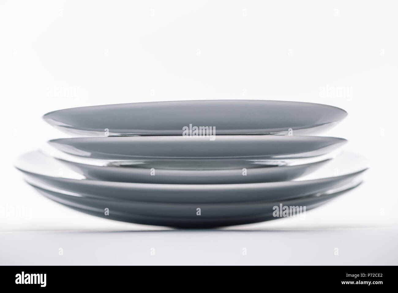 Stack of white porcelain plates on white background Stock Photo - Alamy