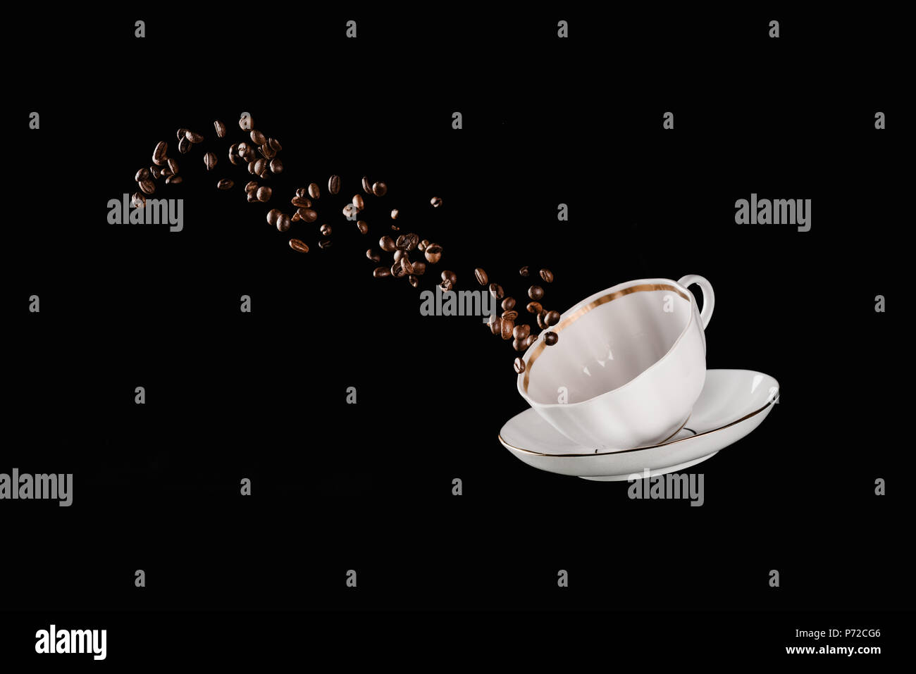 coffee beans falling from cup isolated on black Stock Photo - Alamy