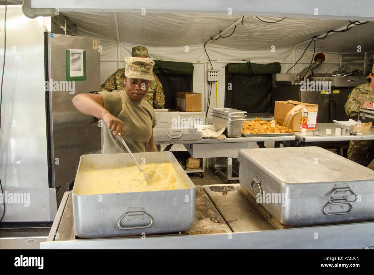 Private 1st Class Desiree Slaton, a food service specialist assigned to E Company, 6th Battalion, 101st General Support Aviation Battalion, 101st Combat Aviation Brigade, 101st Airborne Division, prepares potatoes au gratin for the field feeding portion of the Philip A. Connelly Program May 11, 2017, at Fort Campbell, Kentucky. Two warrant officers from the XVIII Airborne Corps conducted an evaluation of the 101st CAB team to determine if they would advance in the competition. Stock Photo