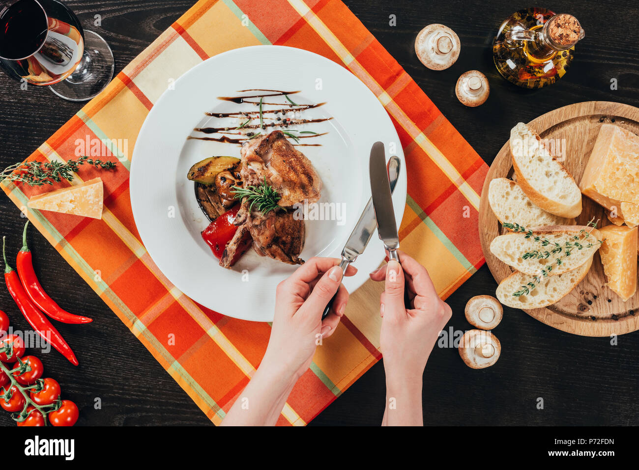 cropped image of woman sharpening knives above grilled chicken Stock Photo