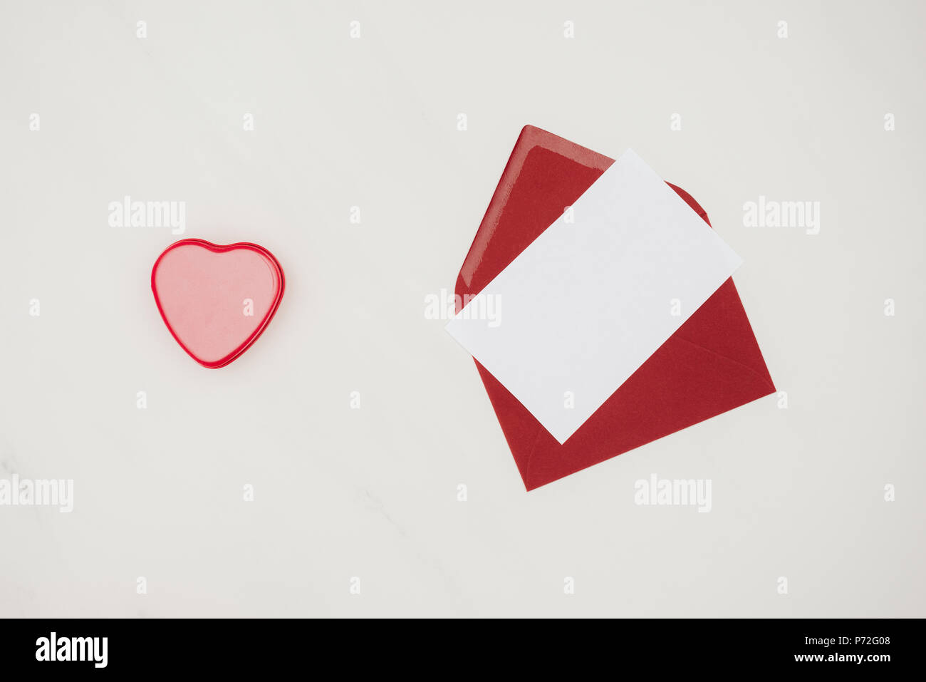 top view of red envelope with blank paper and heart shaped box isolated on white Stock Photo