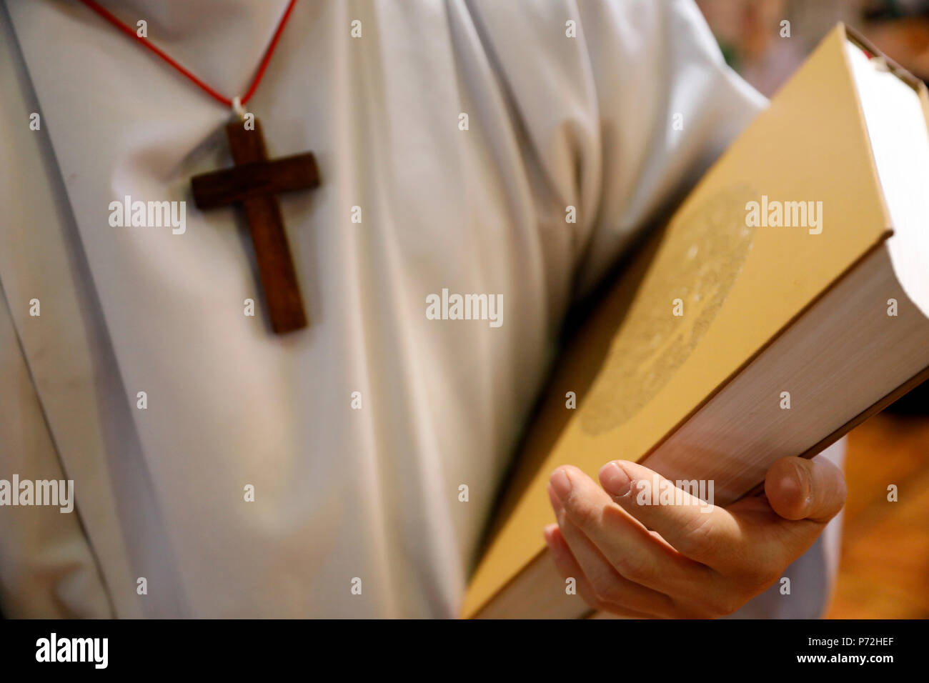 Altar boy with Holy Bible, Catholic Mass, Sallanches, Haute-Savoie, France, Europe Stock Photo