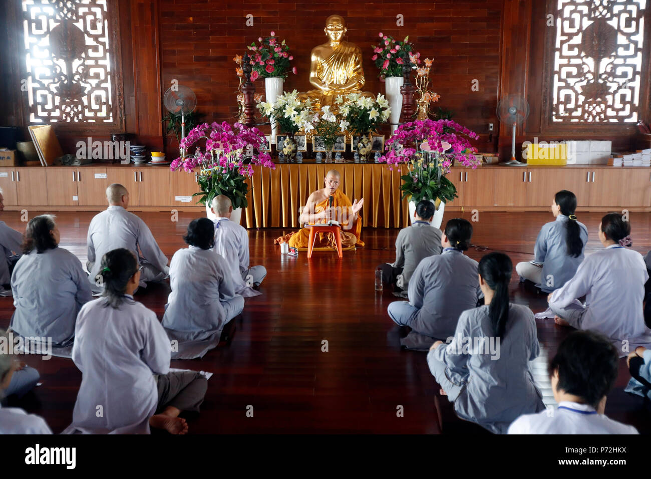 A teacher instructs a group of people how to recite Buddhist chants, Minh Dang Quang Buddhist Temple, Ho Chi Minh City, Vietnam, Indochina, Asia Stock Photo