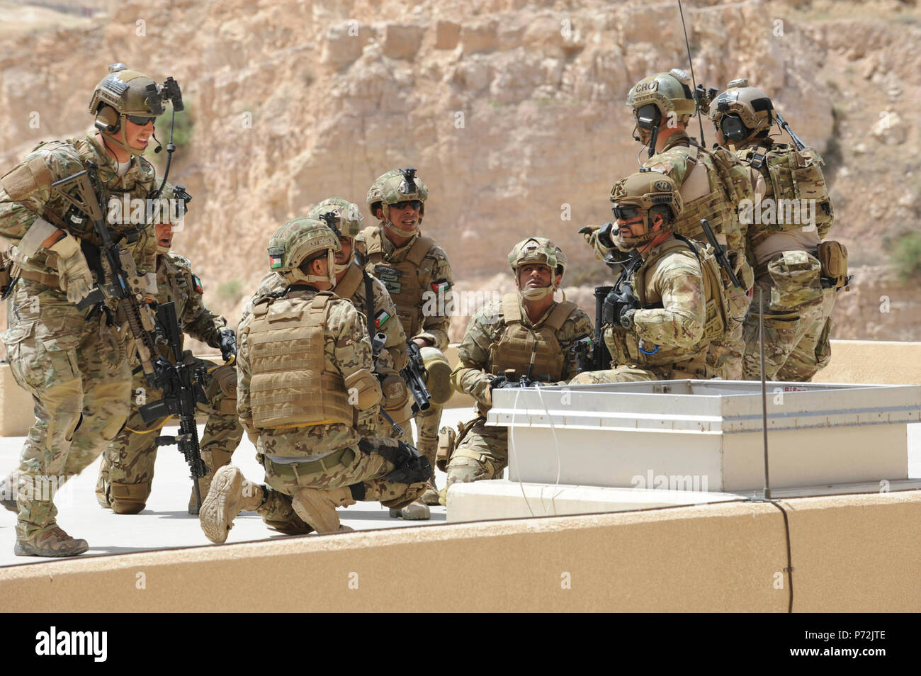 Jordan (May 11, 2017) Members of the Jordanian Armed Forces Special Task Force, U.S. Air Force Special Operations, and Italian Special Operations Wing, prepare to enter a building via rooftop, during an interoperability combat search and rescue training at the King Abdullah II Special Operations Training Center, as part of Exercise Eager Lion. Eager Lion is an annual U.S. Central Command exercise in Jordan designed to strengthen military-to-military relationships between the U.S., Jordan and other international partners. This year's iteration is comprised of about 7,200 military personnel from Stock Photo