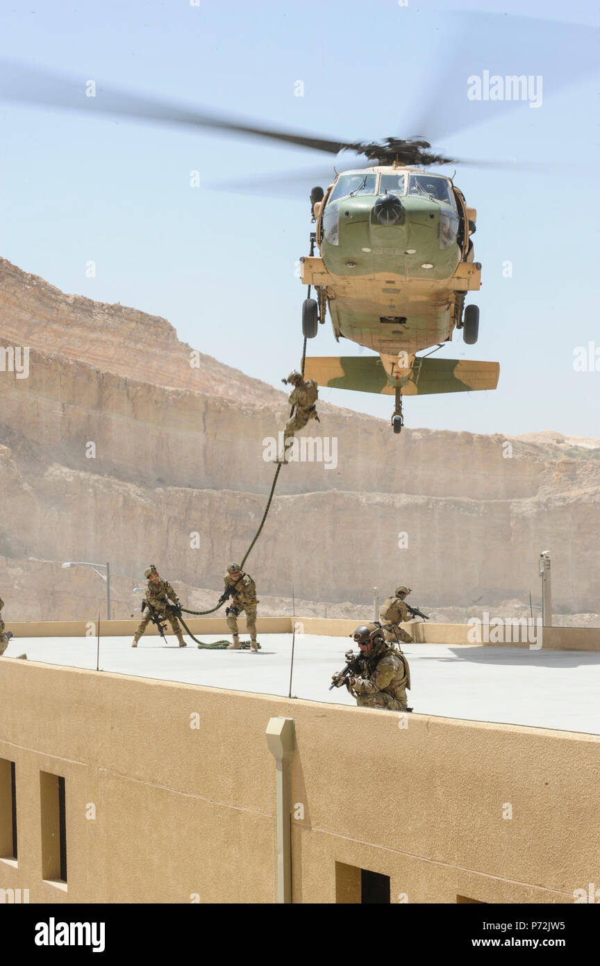 Jordan (May 11, 2017) Members of the U.S. Air Force Special Operations, and Jordanian Armed Forces Special Task Force fast rope drop on to a building, during an interoperability combat search and rescue training at the King Abdullah II Special Operations Training Center, as part of Exercise Eager Lion. Eager Lion is an annual U.S. Central Command exercise in Jordan designed to strengthen military-to-military relationships between the U.S., Jordan and other international partners. This year's iteration is comprised of about 7,200 military personnel from more than 20 nations that will respond to Stock Photo