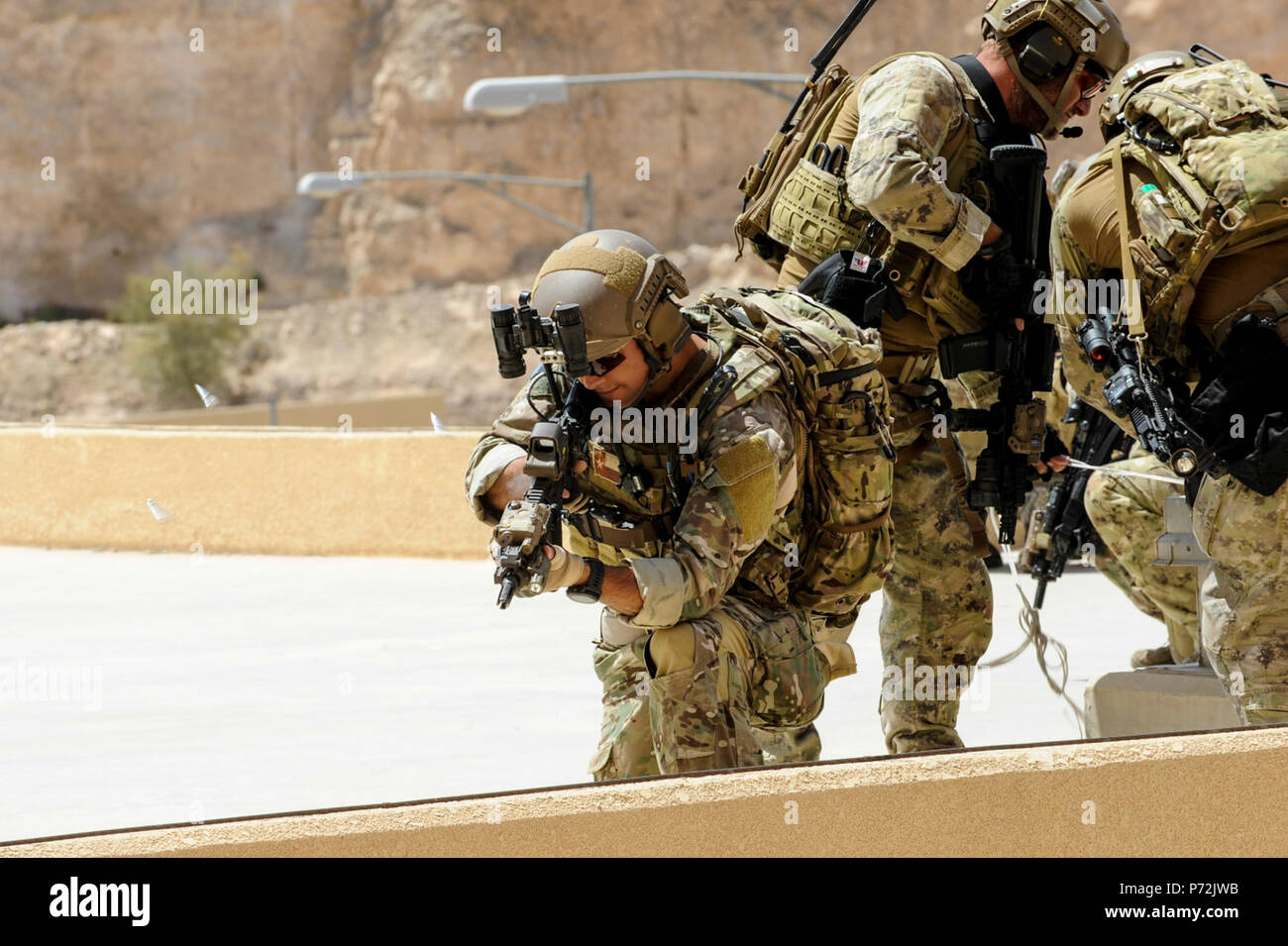 Jordan (May 11, 2017) An Airmen assigned to Air Force Special Operations, provides covering fire as forces fast rope drop on to a building, during an interoperability combat search and rescue training with Jordanian Armed Forces Special Task Force, at the King Abdullah II Special Operations Training Center, as part of Exercise Eager Lion. Eager Lion is an annual U.S. Central Command exercise in Jordan designed to strengthen military-to-military relationships between the U.S., Jordan and other international partners. This year's iteration is comprised of about 7,200 military personnel from more Stock Photo