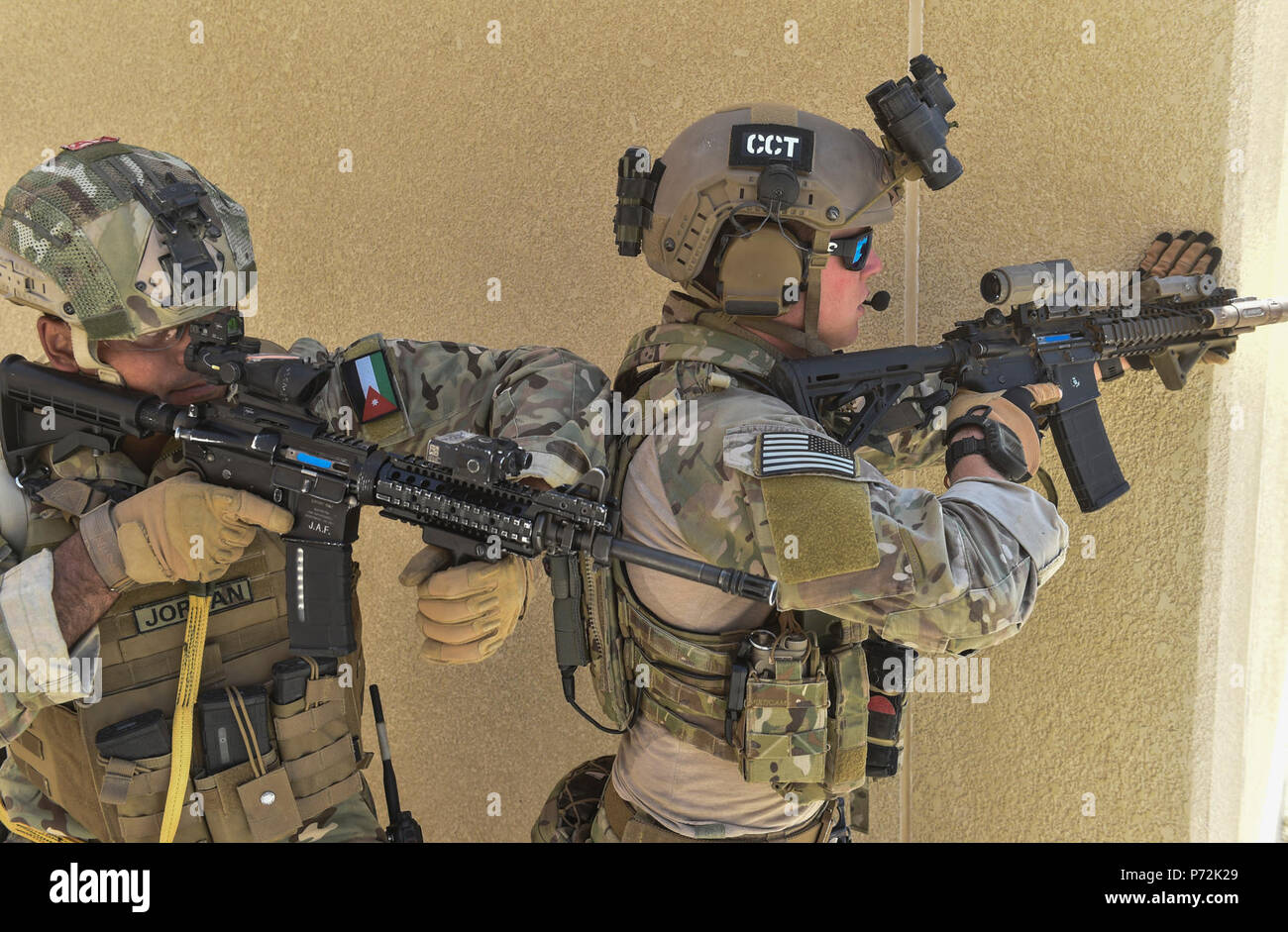 A Jordanian Armed Forces Special Task Force member and an Air Force Special Tactics Airman with the 23rd Special Tactics Squadron, prepare to assault opposing forces during a personnel rescue mission, May 11, 2017, at the King Abdullah II Special Operations Training Center. Eager Lion is an annual U.S. Central Command exercise in Jordan designed to strengthen military-to-military relationships between the U.S., Jordan and other international partners. This year's iteration is comprised of about 7,200 military personnel from more than 20 nations that will respond to scenarios involving border s Stock Photo