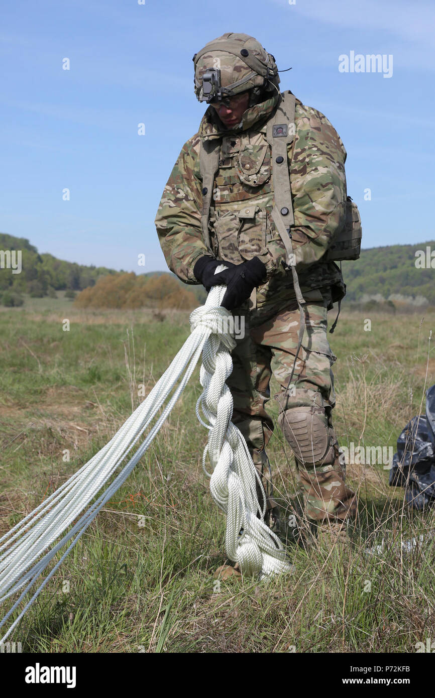U.S. Army Spc. William Dickey of the Regimental Support Squadron, 2d Cavalry Regiment knots up parachute strings while conducting an air resupply mission during Saber Junction 17 at the Hohenfels Training Area, Germany, May 11, 2017. Saber Junction 17 is the U.S. Army Europe’s 2d Cavalry Regiment’s combat training center certification exercise, taking place at the Joint Multinational Readiness Center in Hohenfels, Germany, Apr. 25-May 19, 2017. The exercise is designed to assess the readiness of the regiment to conduct unified land operations, with a particular emphasis on rehearsing the trans Stock Photo